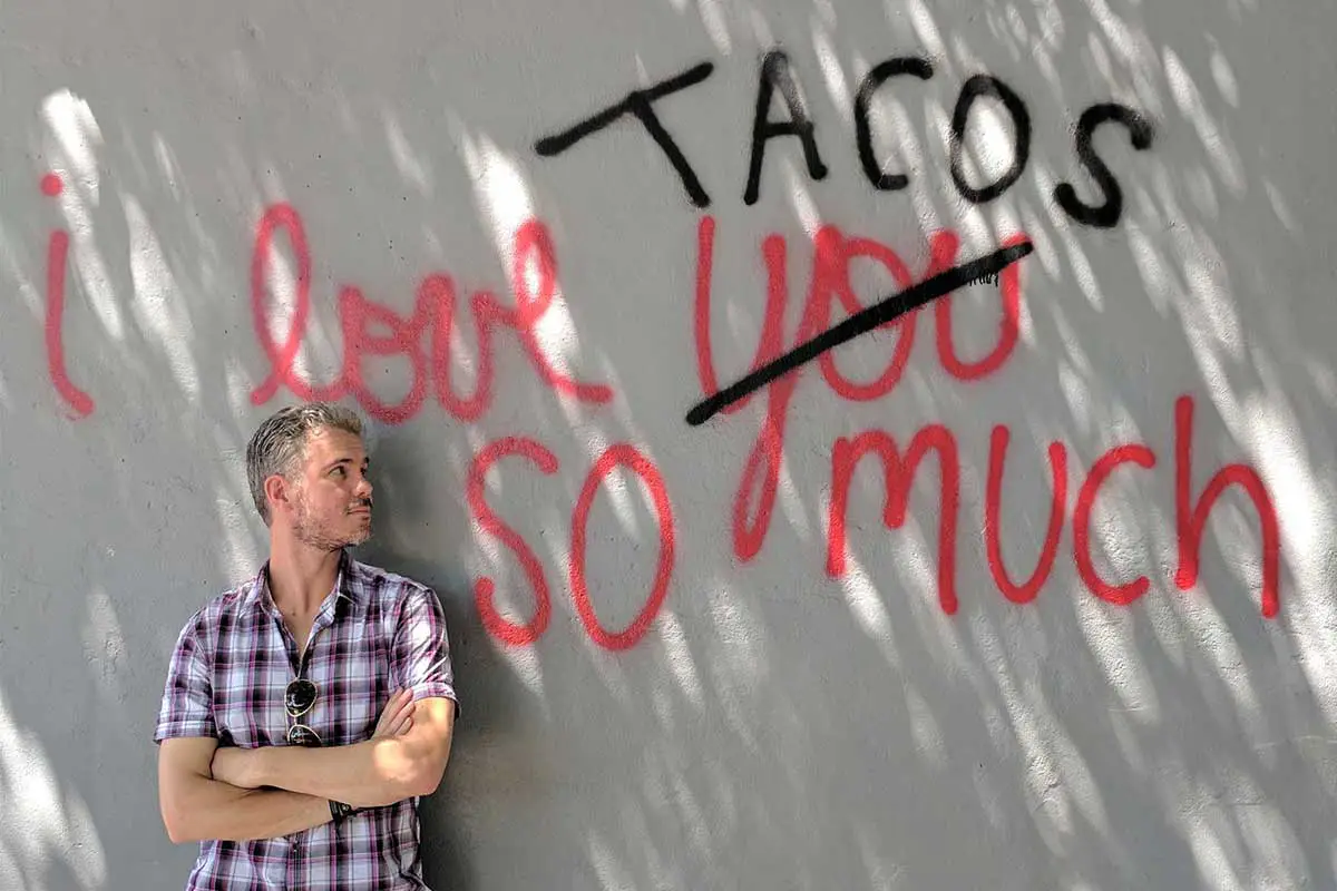 Bret McGowen in front of an I Love Tacos sign